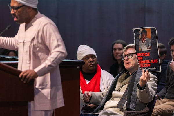 Social justice organizer Tim Franzen (right) protests the death of Cornelius Taylor, an unhoused man killed when the city cleared an encampment last week, inside the council chambers at City Hall in Atlanta on Thursday, January 23, 2025. (Arvin Temkar / AJC)