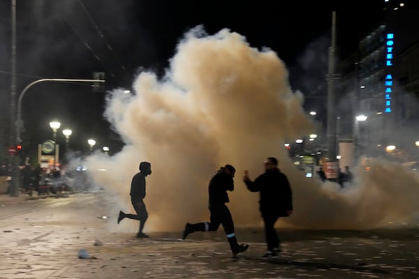 People run to avoid tear gas during clashes with riot police, as the Greek opposition parties have challenged the country's center-right government with a censure motion in parliament over a devastating rail disaster nearly two years ago, in Athens, Wednesday, March 5, 2025. (AP Photo/Petros Giannakouris)