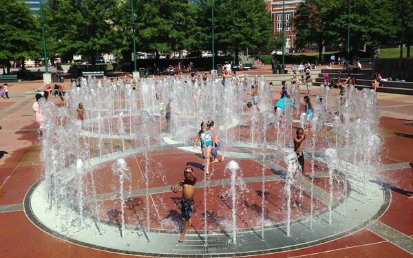 Children running and playing through the fountain rings