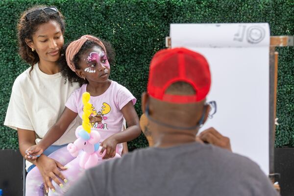 Britnee Narvaez and daughter Mariam Camara sit for their caricature drawing at the SkyView Atlanta Observation Wheel celebration on its 10th anniversary in downtown Atlanta Saturday, July 15, 2023.  (Steve Schaefer/steve.schaefer@ajc.com)