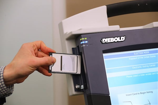 J. Alex Halderman, a professor of computer science at the University of Michigan, wrote a program to alter the results of elections recorded by AccuVote touch-screen voting machines. He installed that program on a rectangular memory card that fits into the side of the machine, allowing the card to infect the machine. Curtis Compton/ccompton@ajc.com