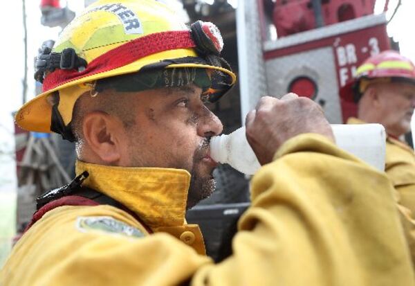 Mark Tabarez takes a water break from fighting the Rock Mountain fire in Rabun County. CURTIS COMPTON / CCOMPTON@AJC.COM