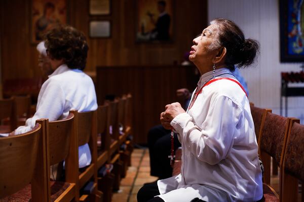 Esther Gianan of Tampa, Florida, a retired registered nurse, prays for those who are affected by the coronavirus during Mass at St. Lawrence Catholic Church. 