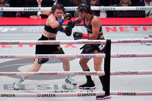 Amanda Serrano, right, hits Katie Taylor during their undisputed super lightweight title bout, Friday, Nov. 15, 2024, in Arlington, Texas. (AP Photo/Julio Cortez)