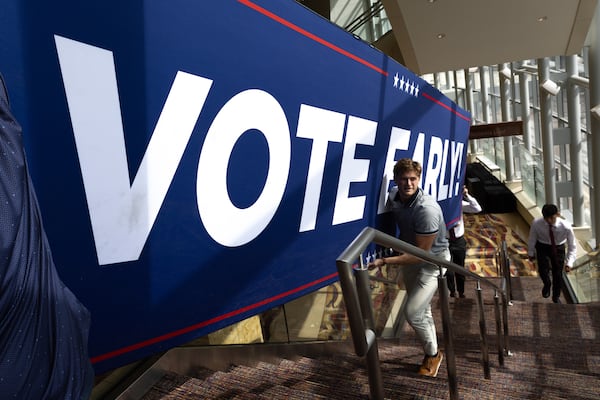 Workers move a sign before a rally host by former President Donald Trump in Cobb County last week.