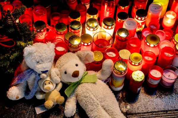 Teddy bears were laid together with candles near the Christmas market, where a car drove into a crowd on Friday evening, in Magdeburg, Germany, Sunday, Dec. 22, 2024. (AP Photo/Michael Probst)