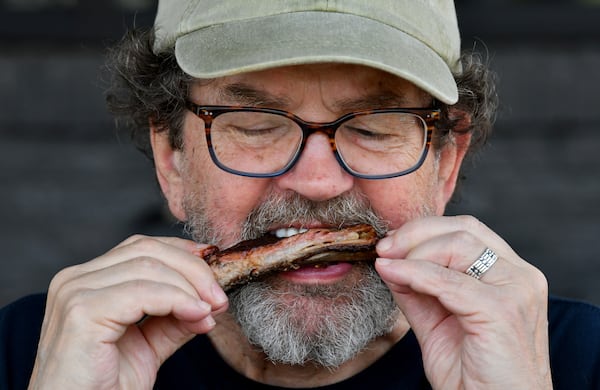 George Hirthler savors a rib at City Barbeque in Sandy Springs. (Hyosub Shin / Hyosub.Shin@ajc.com)