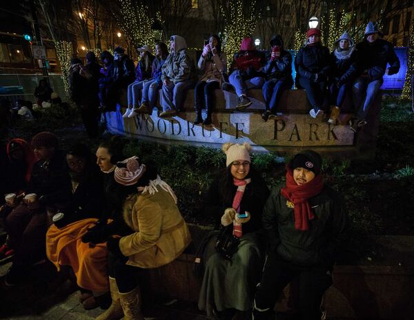 People try to keep warm while waiting for the live entertainment to start at Woodruff Park during the Peach Drop 2017, Sunday, Dec. 31, 2017, in Atlanta. BRANDEN CAMP / SPECIAL TO THE AJC