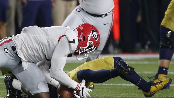 Georgia outside linebacker Lorenzo Carter (7) recovers a fumble from Notre Dame quarterback Brandon Wimbush (7) during the second half of an NCAA college football game in South Bend, Ind., Saturday, Sept. 9, 2017. Georgia won 20-19. (Joshua L. Jones/Athens Banner-Herald via AP)