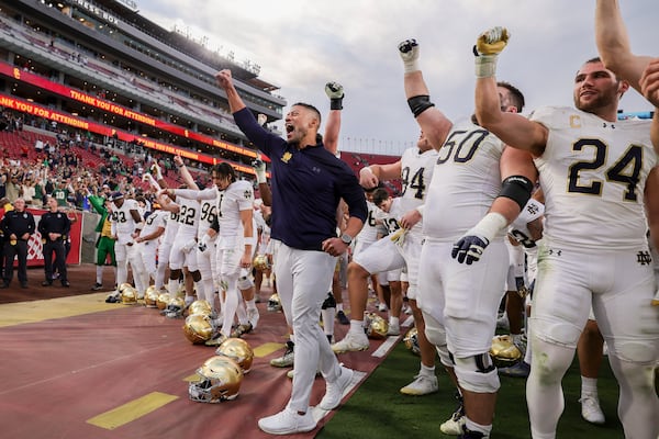 Notre Dame head coach Marcus Freeman, center, chants with his players after the team's win against Southern California in an NCAA football game Saturday, Nov. 30, 2024, in Los Angeles. (AP Photo/Ryan Sun)