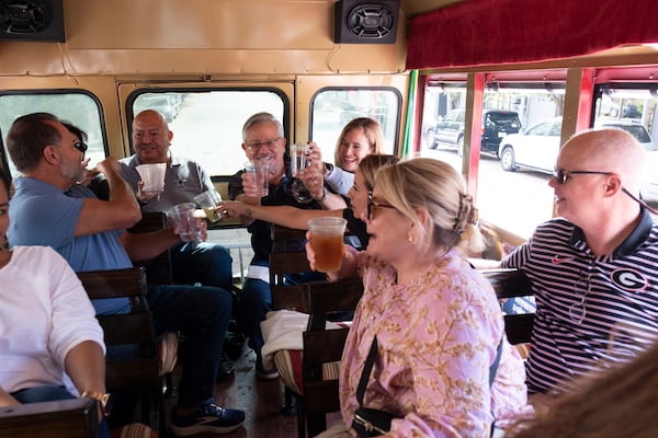 Riders do shots aboard the Funny Bus, where drinking is encouraged, during a tour through Atlanta on Saturday, Nov. 2, 2024. (Ben Gray for the AJC)