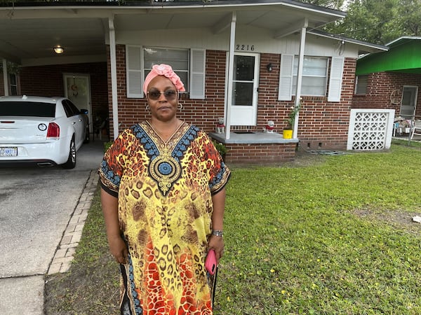 Georgia native and Jacksonville resident Crecie Washington stands in front of her home Sunday after three people were killed in her neighborhood on Saturday.