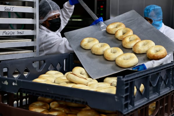 Mainline Aviation employees pull fresh Goldbergs Fine Foods bagels out of the oven on Friday, August 5, 2022. (Natrice Miller/natrice.miller@ajc.com)