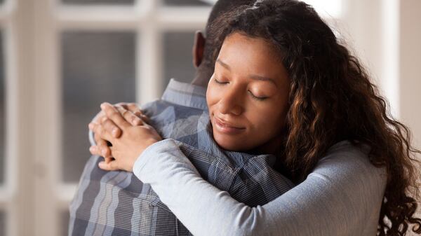 A woman embraces a man.