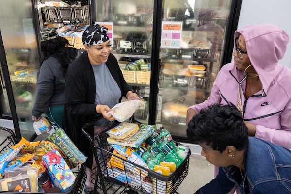 Takisha Brown (second from left) picks up groceries at Jonesboro Community Food Center in Jonesboro on Monday, November 18, 2024. (Arvin Temkar / AJC)