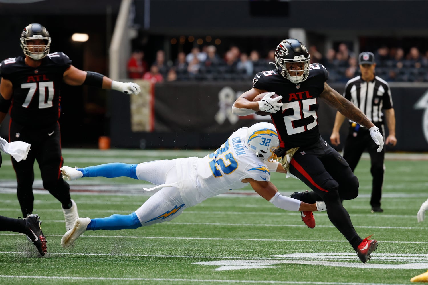 Falcons running back Tyler Allgeier eludes Chargers safety Alohi Gilman during the third quarter Sunday in Atlanta. 
(Miguel Martinez / miguel.martinezjimenez@ajc.com)