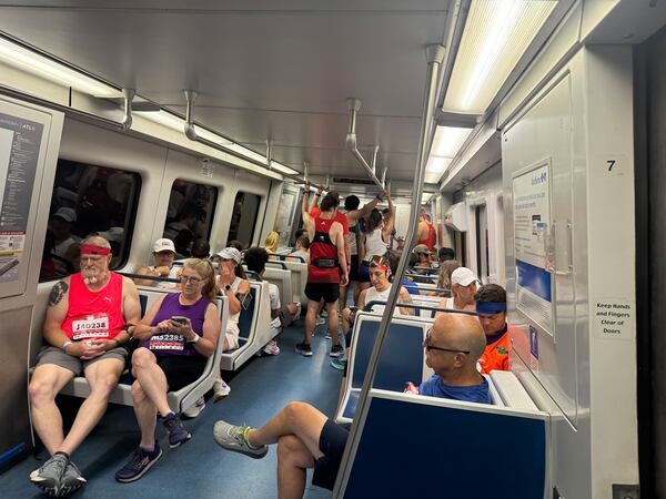 Runners fill MARTA trains early Thursday morning, July 4 ,2024, on their way to compete in The Atlanta Journal-Constitution Peachtree Road Race.