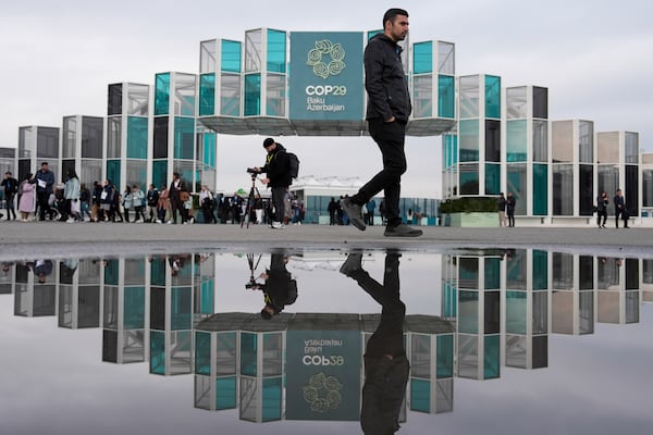 FILE - People arrive for the day at the COP29 U.N. Climate Summit, Nov. 19, 2024, in Baku, Azerbaijan. (AP Photo/Joshua A. Bickel, File)