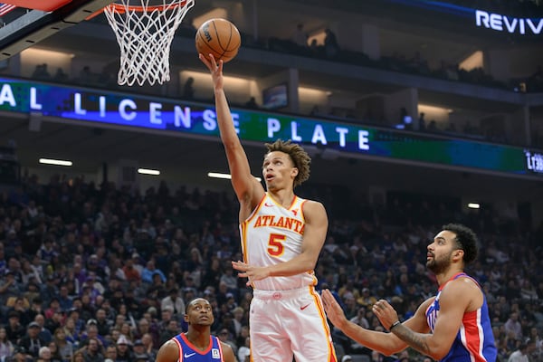 Atlanta Hawks guard Dyson Daniels (5) lays the ball up over Sacramento Kings forward Trey Lyles, right, during the first half of an NBA basketball game in Sacramento, Calif., Monday, Nov. 18, 2024. (AP Photo/Randall Benton)