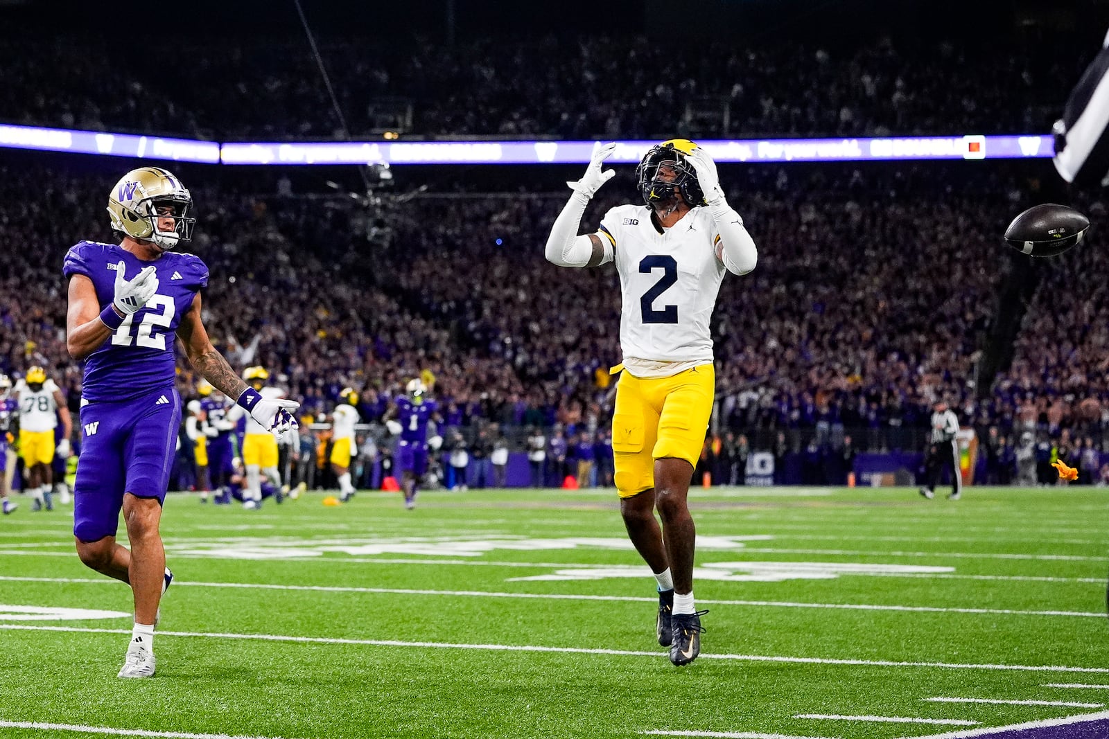 Michigan defensive back Will Johnson (2) reacts to being called for pass interference against Washington wide receiver Denzel Boston (12) during the second half of an NCAA college football game Saturday, Oct. 5, 2024, in Seattle. Washington won 27-17. (AP Photo/Lindsey Wasson)