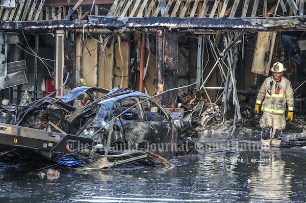 The fire caused structural damage at the business strip, which needed to be addressed before crews could remove the charred Porsche Cayenne from the wreckage.