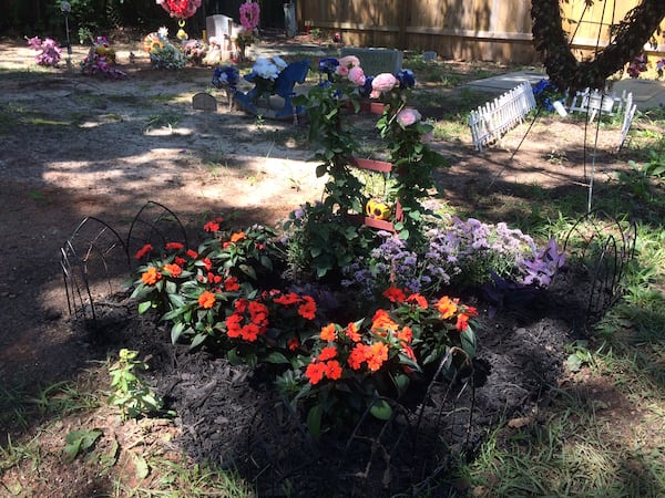 Louis Williams II planted flowers at his daughter's grave Thursday night in Goose Creek, SC