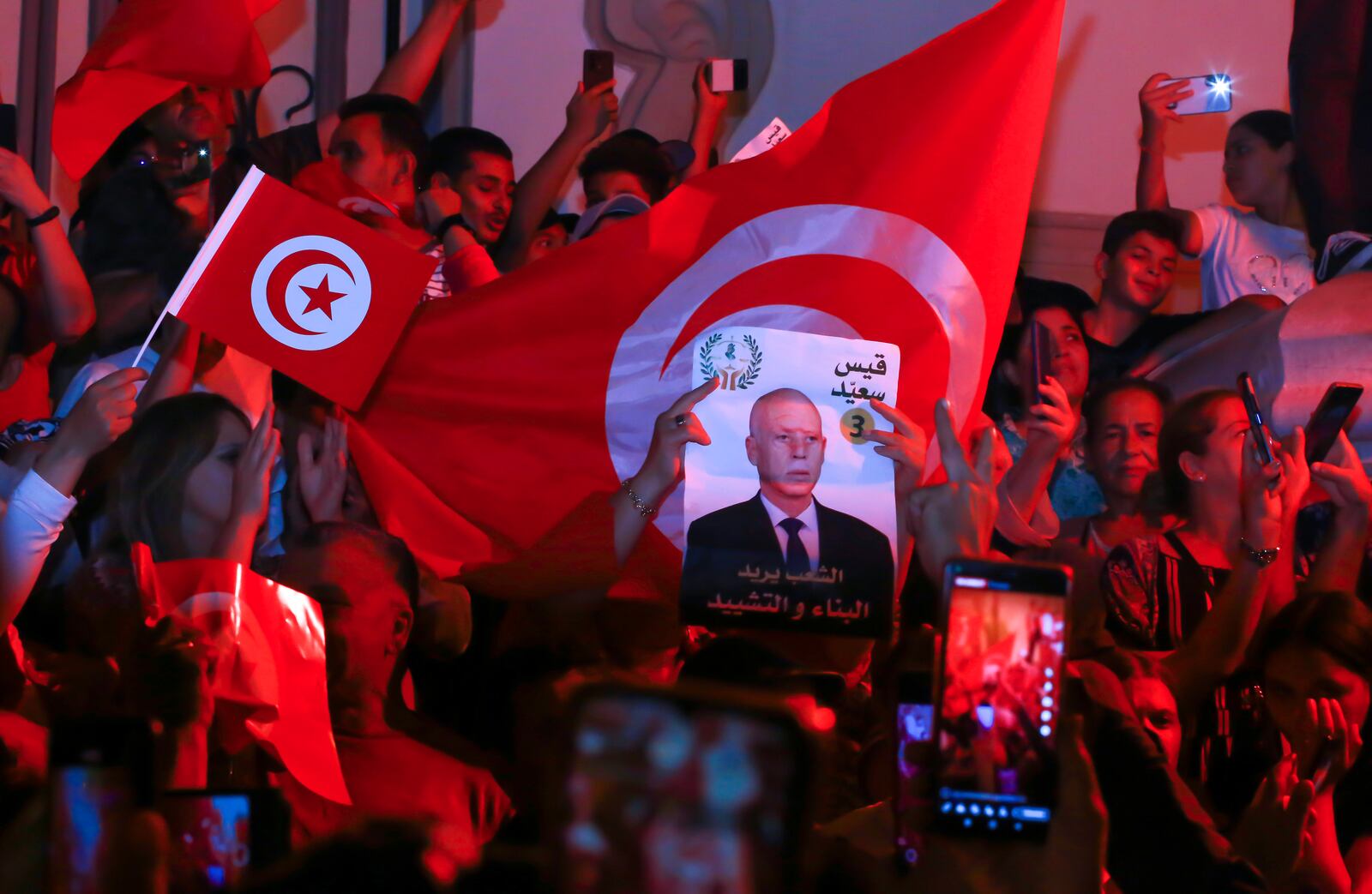 Supporters of Tunisian president and candidate for re-election Kais Saied celebrate after the announcement of the provisional results for the presidential elections, in the capital Tunis, Tunisia, Sunday, Oct. 6, 2024. (AP Photo/Anis Mili)