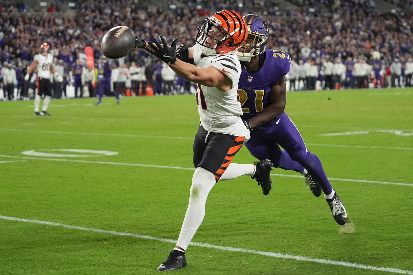 Cincinnati Bengals wide receiver Jermaine Burton (81) reaches for an incomplete pass as Baltimore Ravens cornerback Brandon Stephens (21) defends during the second half of an NFL football game, Thursday, Nov. 7, 2024, in Baltimore. (AP Photo/Stephanie Scarbrough)