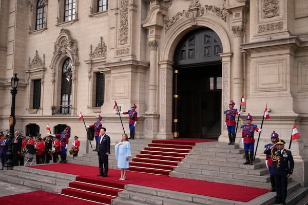 South Korea's President Yoon Suk Yeol, left, and Peru's President Dina Boluarte stand for the playing of their national anthems during a welcoming ceremony at the government palace in Lima, Peru, Saturday, Nov. 16, 2024, following the closing of the Asia-Pacific Economic Cooperation (APEC) summit. (AP Photo/Fernando Vergara)