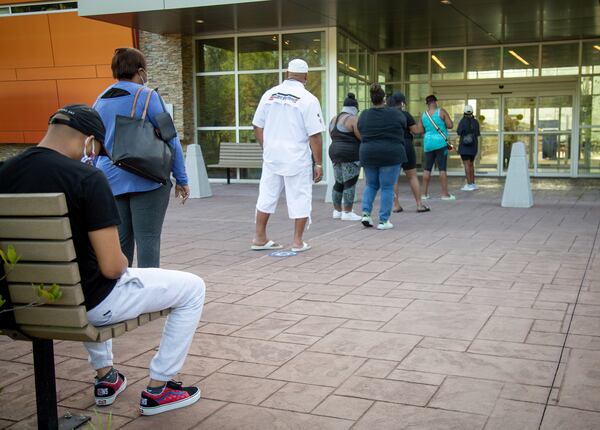 People practice social distancing Saturday at the Wolf Creek Library in Atlanta while waiting to cast their ballots during in-person early voting for Tuesday's runoffs. The coronavirus pandemic added to the difficulties of running the Georgia primary on June 9 when numerous polling sites were overwhelmed as voters waited in lines for hours. STEVE SCHAEFER / SPECIAL TO THE AJC