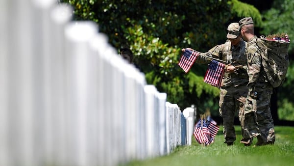 Members of the 3d U.S. Infantry Regiment, also known as The Old Guard, place flags in front of each headstone for "Flags-In" at Arlington National Cemetery in Arlington, Va., Thursday, May 23, 2019, to honor the Nation's fallen military heroes. 