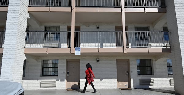 Resident recently walks below the window of an extended stay motel in Norcross. For low-wage workers, extended stay has been an alternative to homelessness, but many have lost their jobs. (Hyosub Shin / Hyosub.Shin@ajc.com)