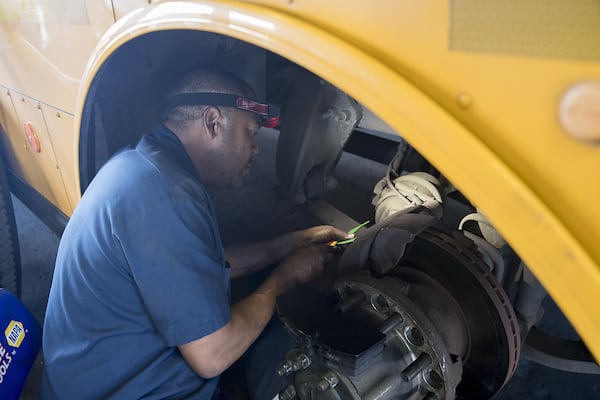 Harvey Barnerd prepares to change the brakes on a school bus at the Atlanta Public Schools Transportation hub in Atlanta’s Sylvan Hills community, Friday, May 31, 2019. (Alyssa Pointer/alyssa.pointer@ajc.com)