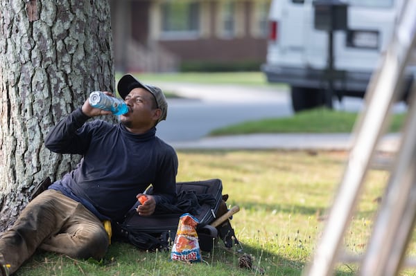 Martin Martin drinks a cold Powerade as warm temperatures heat up beforedoing construction on a house in Atlanta. (Michael Blackshire/Michael.blackshire@ajc.com)