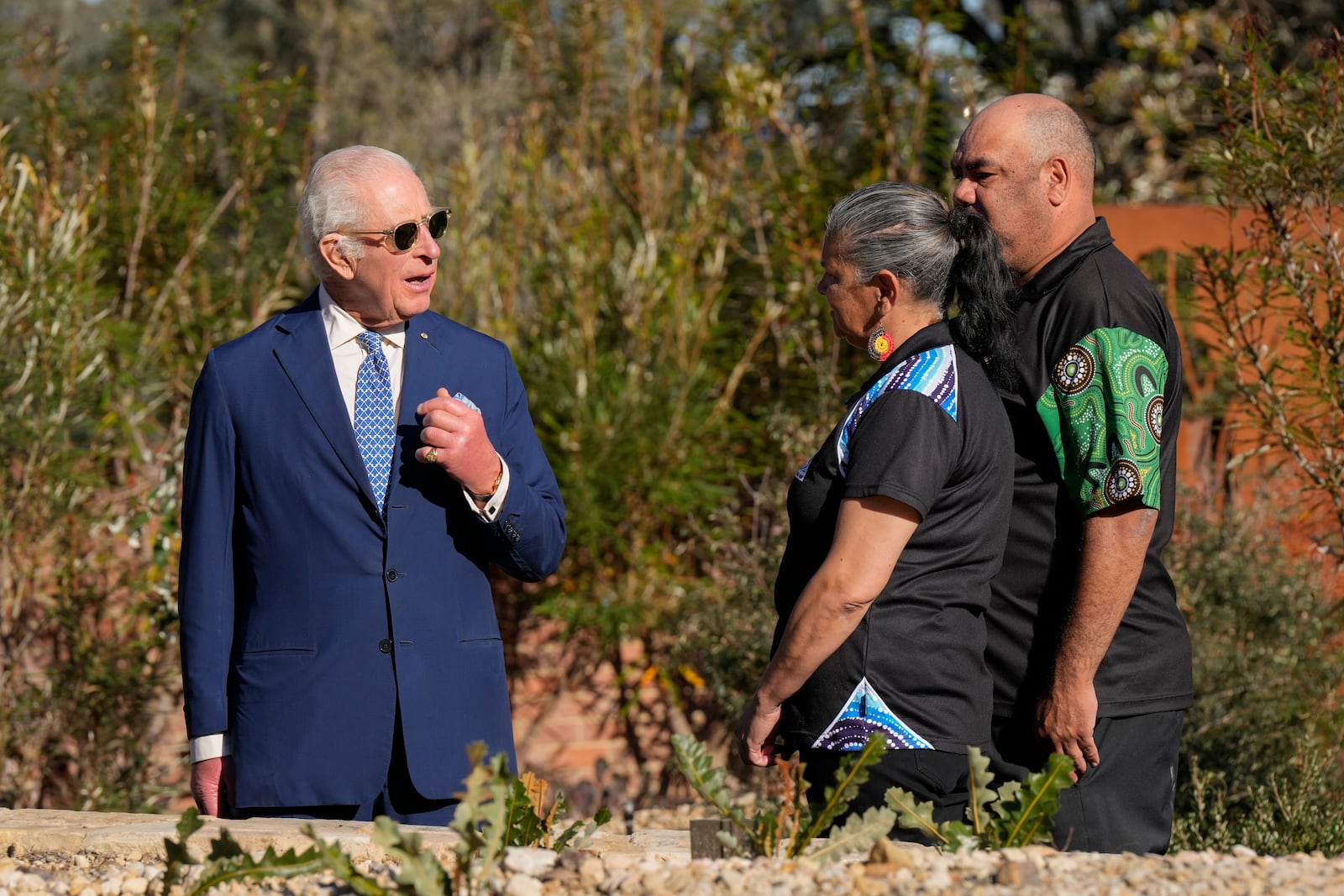 Britain's King Charles III, left, talks with staff during a visit to Australian National Botanic Gardens in Canberra, Monday, Oct. 21, 2024. (AP Photo/Mark Baker, Pool)