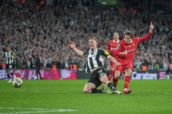 Liverpool's Federico Chiesa, right, scores his side's opening goal during the EFL Cup final soccer match between Liverpool and Newcastle at Wembley Stadium in London, Sunday, March 16, 2025. (AP Photo/Alastair Grant)