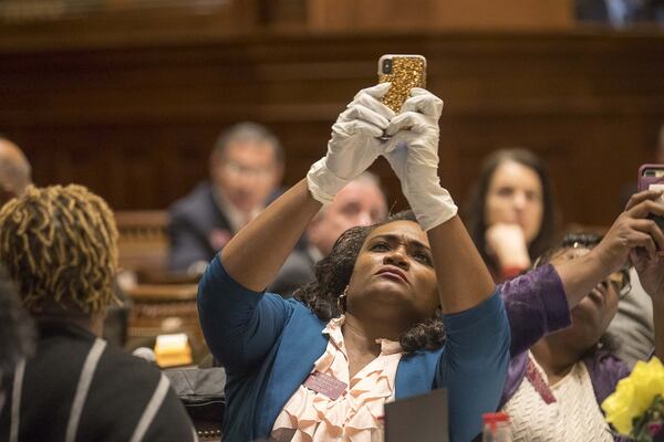 Georgia Rep. Donna McLeod, D - Lawrenceville, takes a photo of the final vote on the House resolution while wearing gloves during a special called session at the Georgia State Capitol Building, Monday, March 16, 2020. (ALYSSA POINTER/ALYSSA.POINTER@AJC.COM)