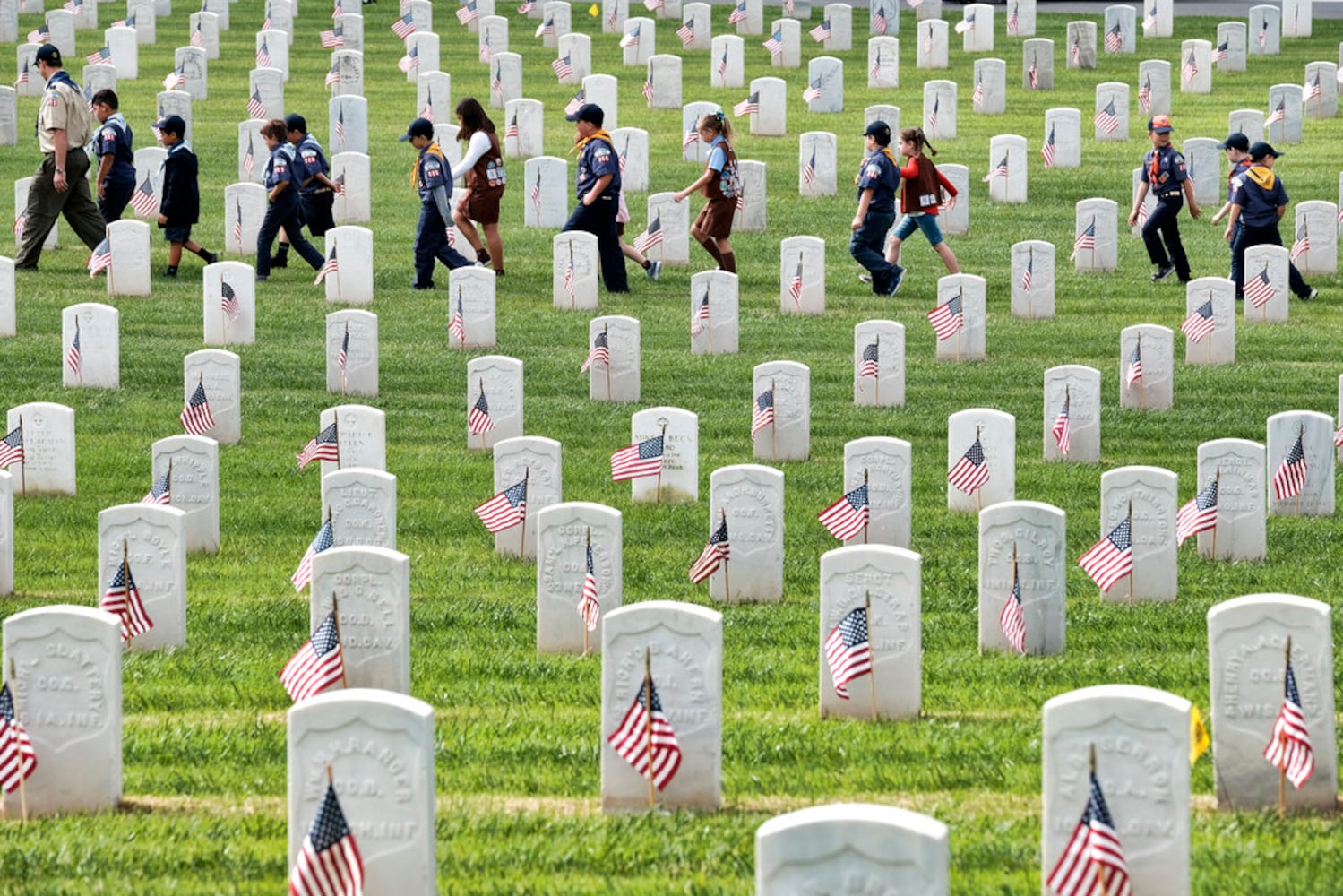 scouts place flags at veteran graves to honor memorial day