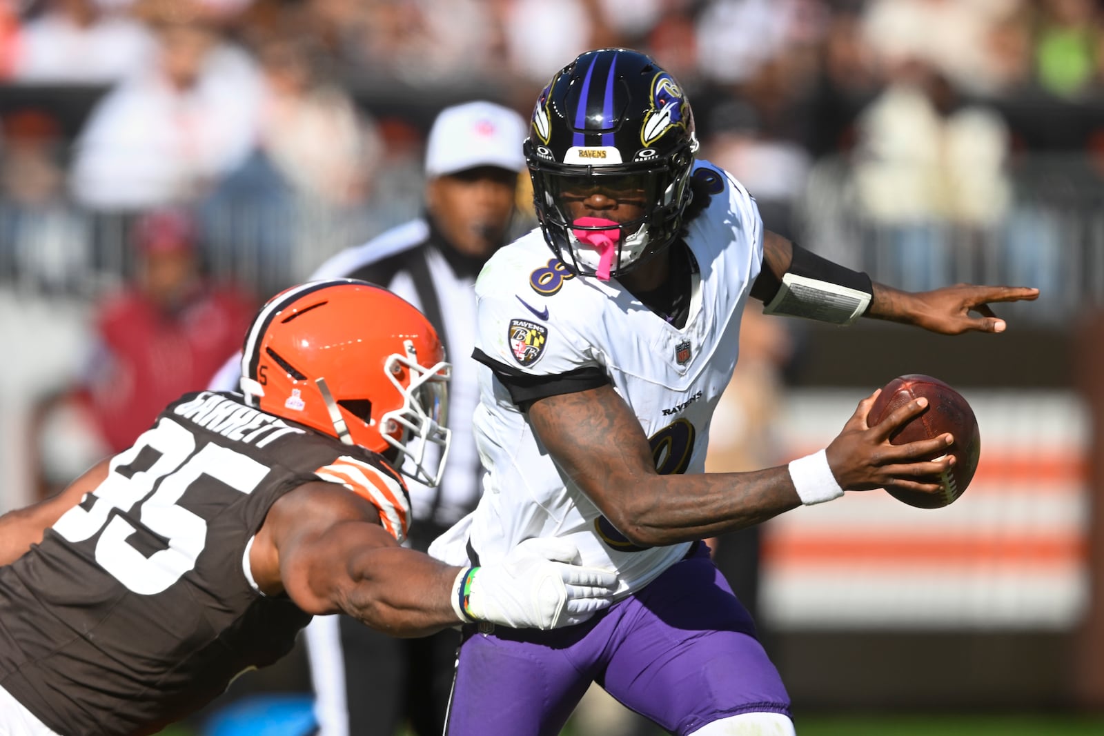 Baltimore Ravens quarterback Lamar Jackson (8) escapes from Cleveland Browns defensive end Myles Garrett (95) during the second half of an NFL football game in Cleveland, Sunday, Oct. 27, 2024. (AP Photo/David Richard)