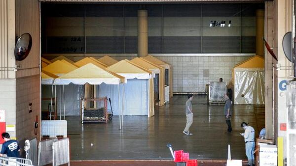 Workers prepare the Ernest N. Morial Convention Center Hall J on Friday, March 27, 2020, in New Orleans after Louisiana state health officials said they are planning to put more than 1,100 beds in the makeshift hospital for patients with the coronavirus. (David Grunfeld/The Advocate via AP)