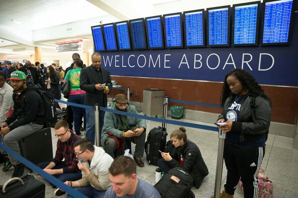 Delta passengers wait in line at Hartsfield-Jackson International Airport after Delta Air Lines grounded all domestic flights due to automation issues, Sunday, Jan. 29, 2017, in Atlanta. (AP Photo/Branden Camp)