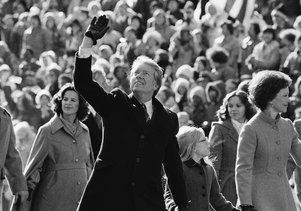 President Jimmy Carter waves to the crowd while walking with his wife, Rosalynn, and their daughter, Amy, along Pennsylvania Avenue from the Capitol to the White House following his inauguration on Jan. 20, 1977, in Washington, D.C. (Suzanne Vlamis/AP)