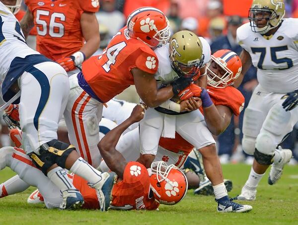 Georgia Tech quarterback Justin Thomas is tackled by Clemson's B.J. Goodson, left, Carlos Watkins, right, and T.J. Burrell during the first half of an NCAA college football game Saturday, Oct. 10, 2015, in Clemson, S.C. (AP Photo/Richard Shiro)