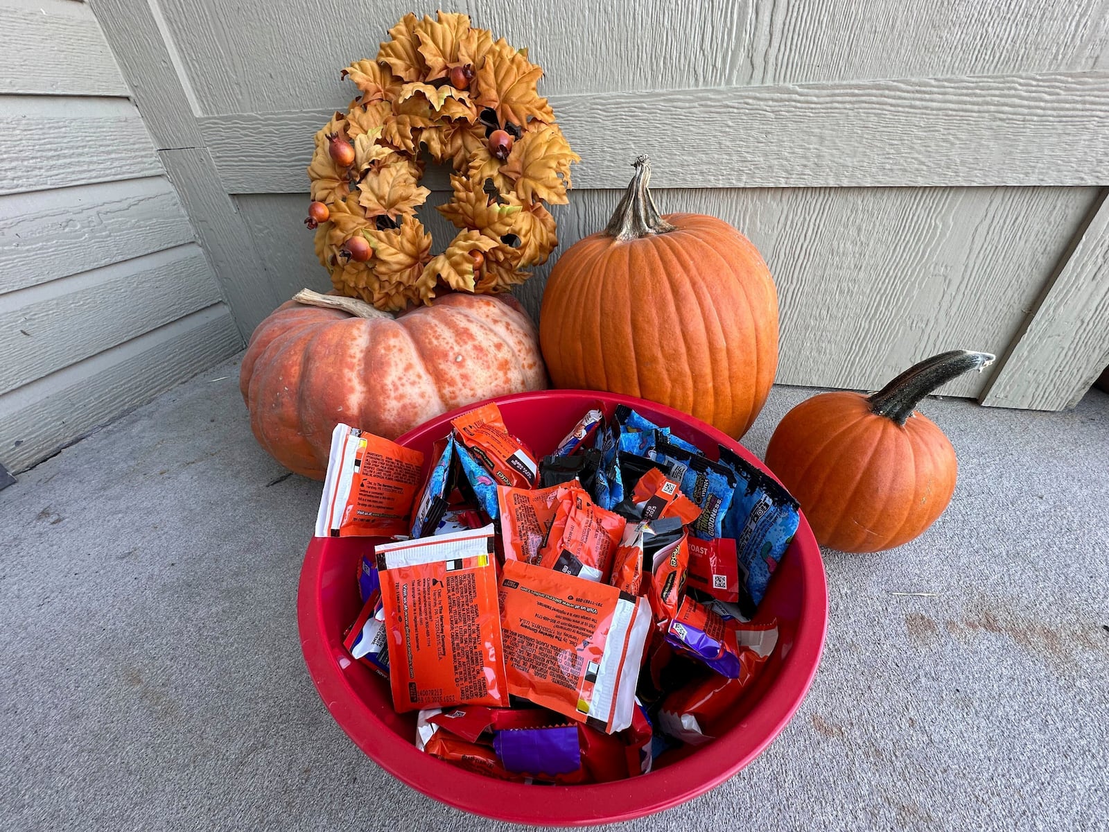 Halloween candy and pumpkins sit outside of a home Friday, Oct. 11, 2024, in St. Joseph, Mo. (AP Photo/Nick Ingram)