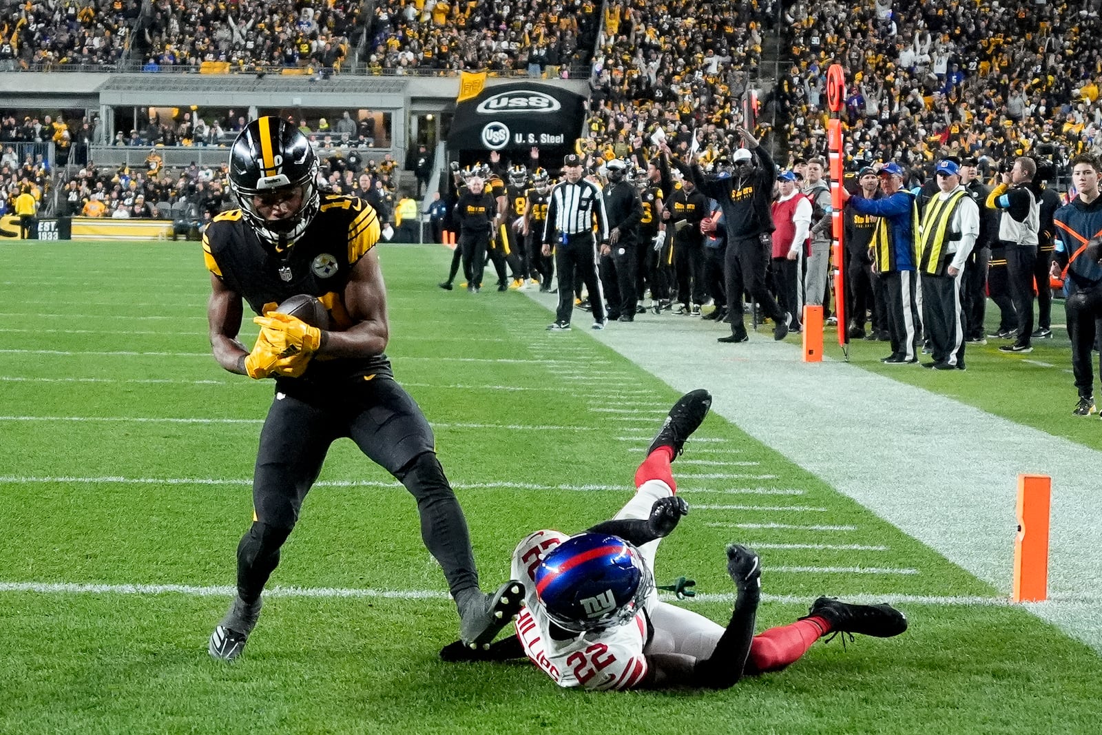 Pittsburgh Steelers wide receiver Calvin Austin III (19) catches a touchdown next to New York Giants cornerback Dru Phillips (22) during the second half of an NFL football game Monday, Oct. 28, 2024, in Pittsburgh. (AP Photo/Gene J. Puskar)