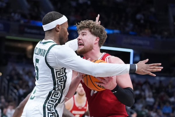 Wisconsin guard Max Klesmit (11) drives on Michigan State guard Tre Holloman (5) during the second half of an NCAA college basketball game in the semifinals of the Big Ten Conference tournament in Indianapolis, Saturday, March 15, 2025. (AP Photo/Michael Conroy)