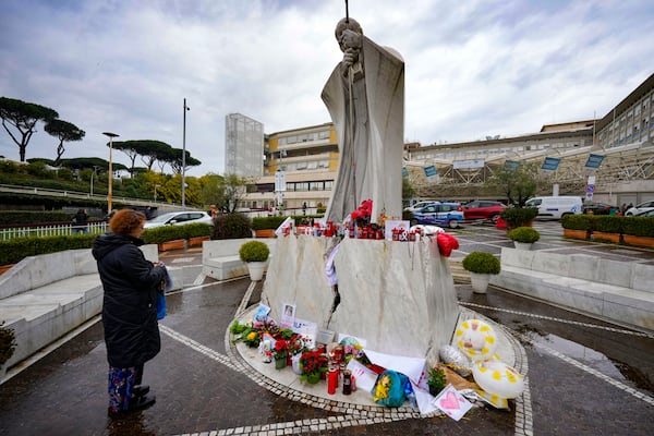 A woman prays for Pope Francis in front of the Agostino Gemelli Polyclinic, in Rome, where the Pontiff has been hospitalized since Feb. 14, Wednesday, Feb. 26, 2025. (AP Photo/Andrew Medichini)