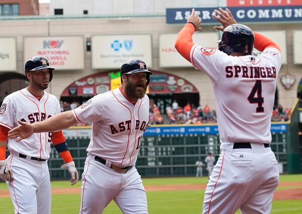 Evan Gattis (centro), de los Astros de Houston, celebra con su compañero George Springer luego de conectar un jonrón de tres carreras frente a los Marineros de Seattle, el domingo 3 de mayo de 2015 (AP Foto/George Bridges) El Oso Blanco has emerged from hibernation. (AP Photo/George Bridges)