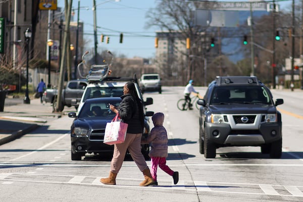 Pedestrians cross Ponce de Leon Avenue at the intersection at Monroe Drive NE on Feb. 21 in Atlanta. This intersection is one of a several slated for upgrades under infrastructure bond program projects. (Jason Getz/AJC)