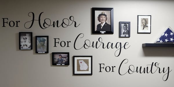 Janice Benario’s portrait (top center) is prominent in the display of veterans photos in the lobby of her apartment building. Janice Benario, 95, was “drafted” from Goucher College to train as one of the first women officers in the Navy and then sworn to secrecy as she and colleagues gathered information for the war effort. BOB ANDRES /BANDRES@AJC.COM